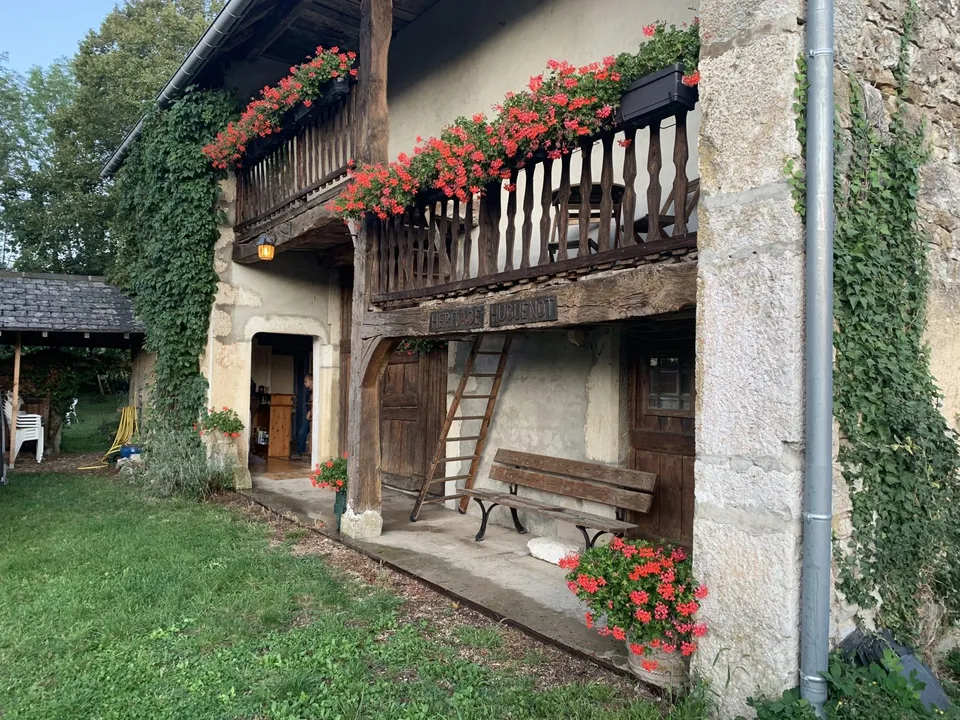 The Foucachon farmhouse in Lompnieu, with its wooden balcony and geraniums